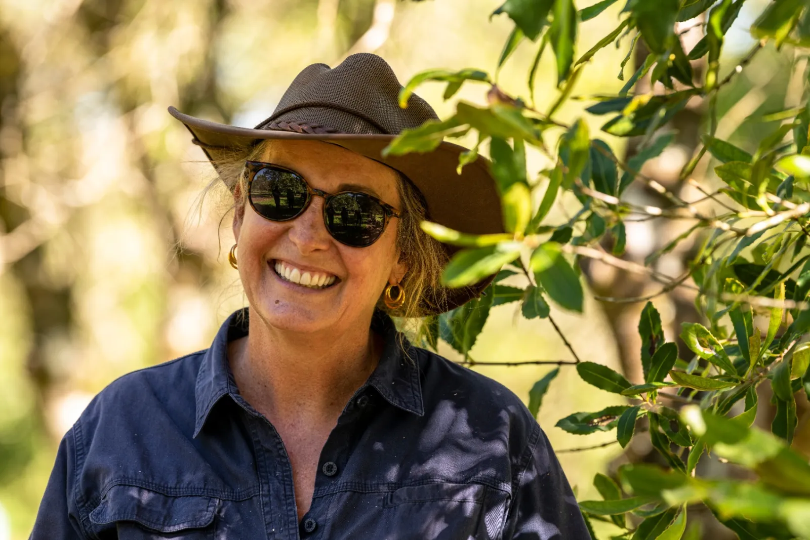 Portrait of Fiona Grigg smiling in the orchard at Zest Macadamias