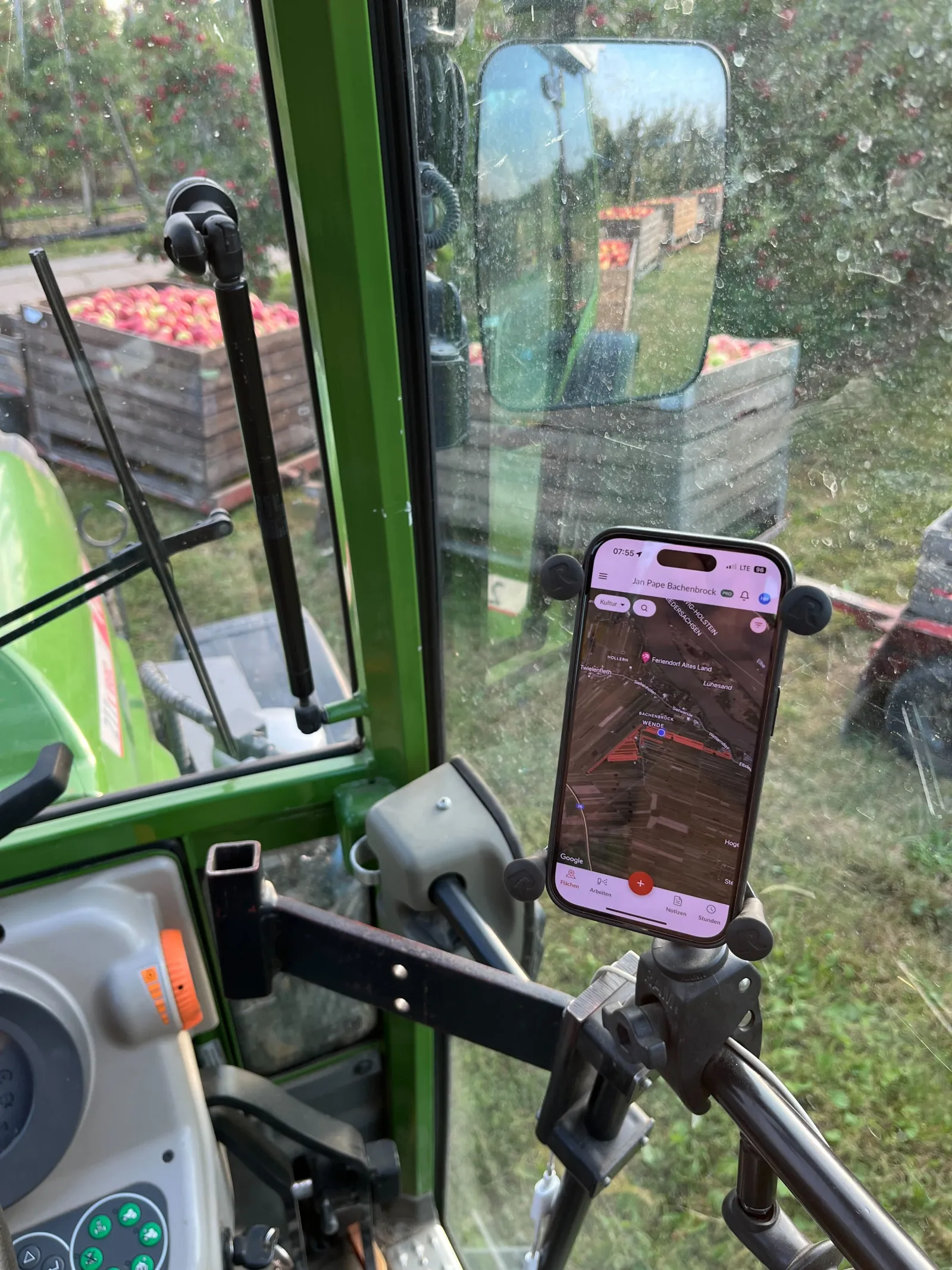 Farmer using the Farmable app mounted in a tractor cab during apple harvest