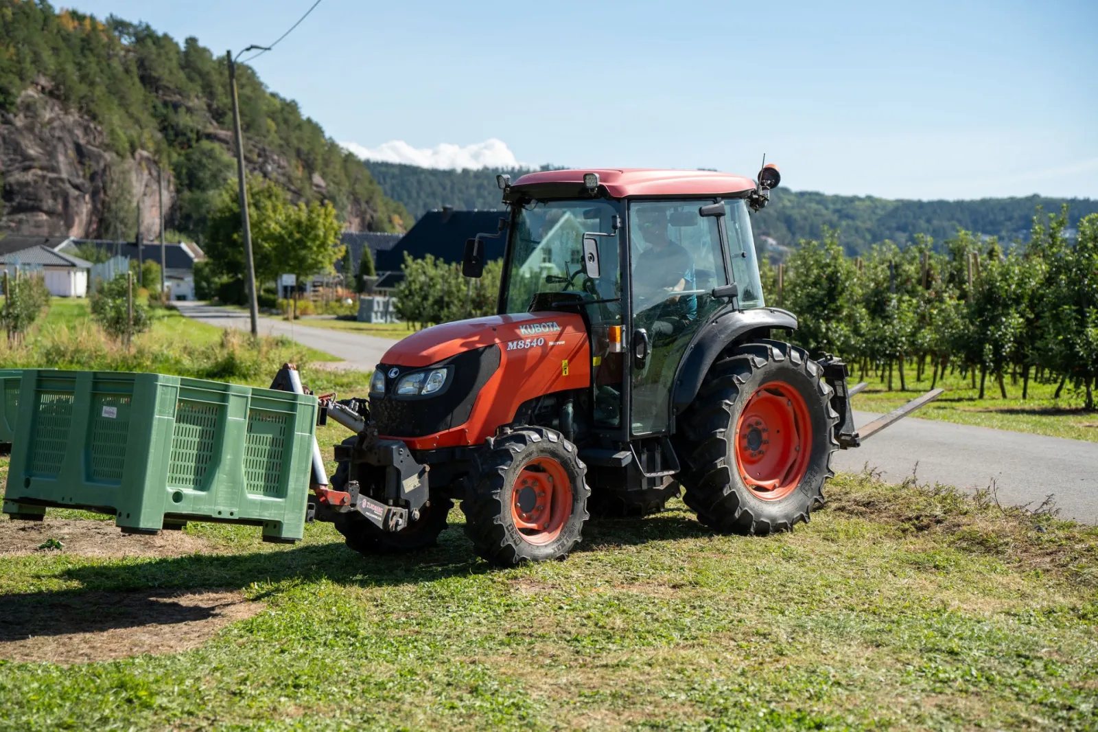 Traktor und Kisten zwischen den Reihen auf Fruktgården